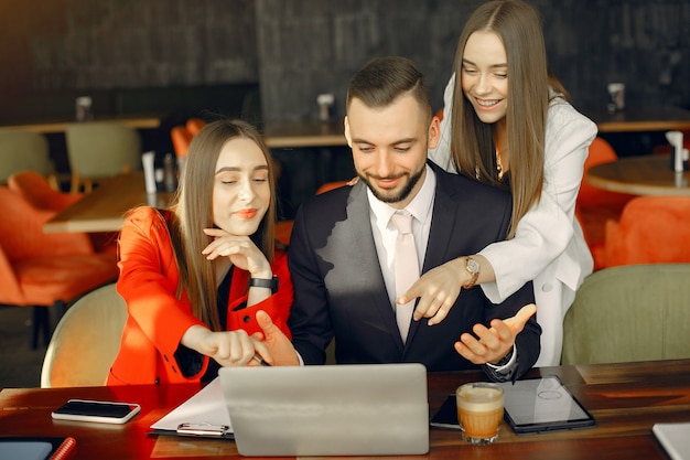 Socios sentados a la mesa y trabajando en un café