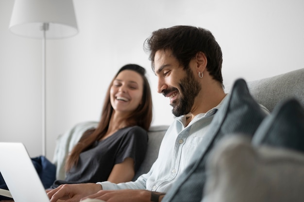 Socios sonrientes de tiro medio relajándose en el sofá