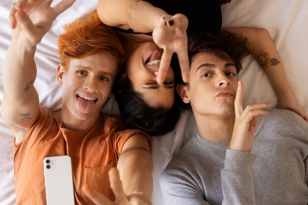 Socios de vista superior tomando selfie en la cama