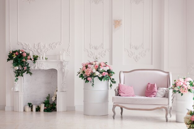 Sofá clásico del estilo de la materia textil blanca en sitio del vintage. Flores ob barriles pintados.