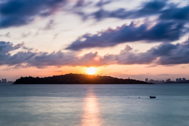 Sol y crepúsculo nube de movimiento en el mar