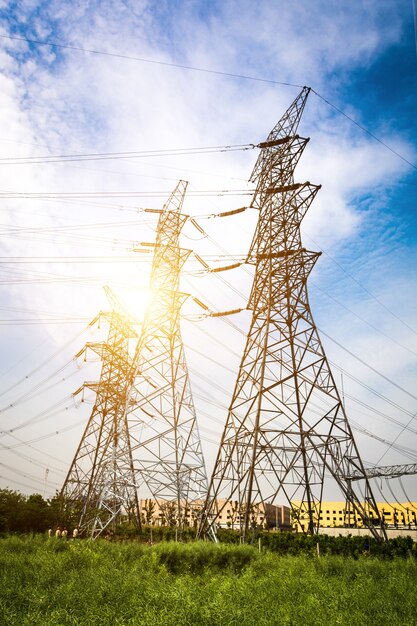 Sol detrás de la silueta de las torres de electricidad