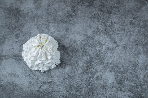 Una sola galleta de merengue blanco aislado en el suelo.