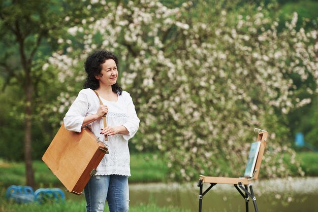 Una sola persona. Pintor maduro con estuche de instrumentos pasear por el hermoso parque de la primavera