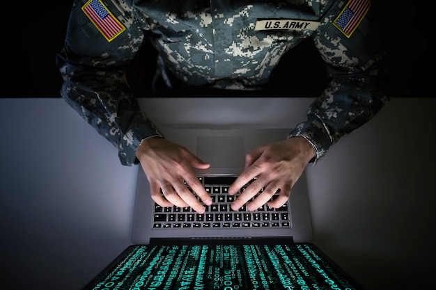Soldado estadounidense en uniforme militar que previene un ataque cibernético en el centro de inteligencia militar