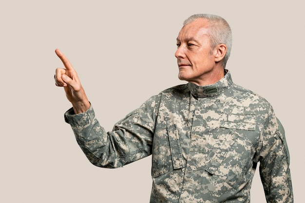 Soldado masculino presionando el dedo índice en una pantalla invisible