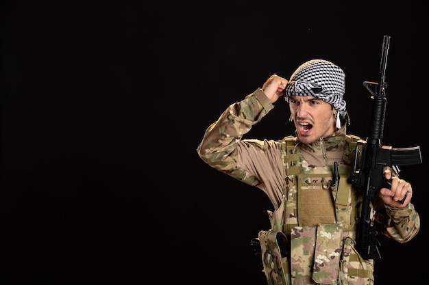Soldado palestino en camuflaje con ametralladora en el escritorio negro tanque guerra palestina