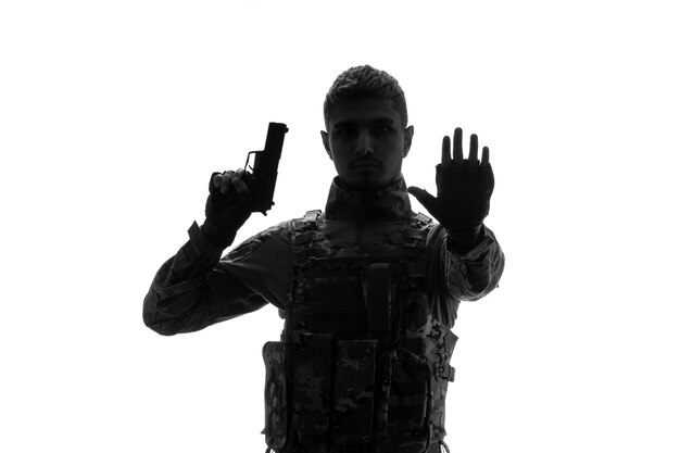 Soldado silueta duro guapo serio fuerte soldado del ejército en uniforme levantando la mano