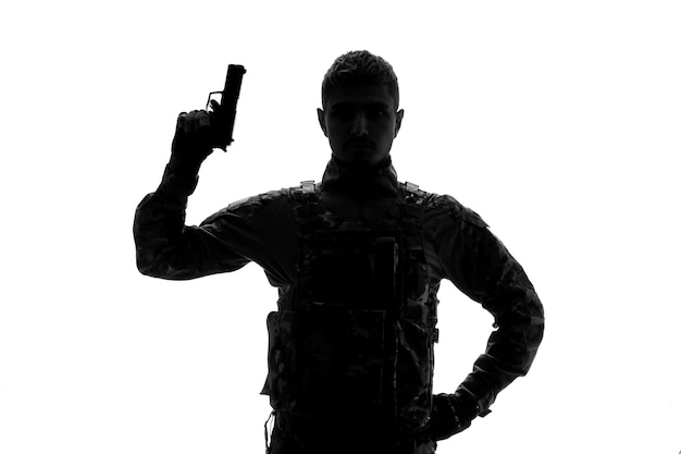 Soldado silueta duro guapo serio fuerte soldado del ejército en uniforme con pistola