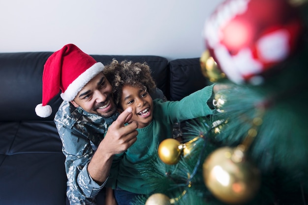 Soldado en uniforme sorprendiendo a su hija y celebrando la Navidad juntos