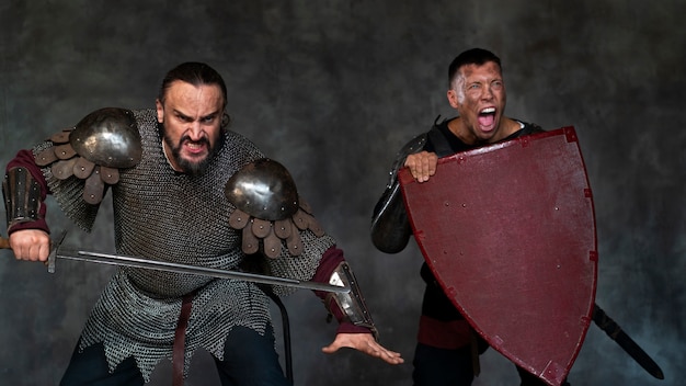 Foto gratuita soldados medievales de tiro medio posando en el estudio.