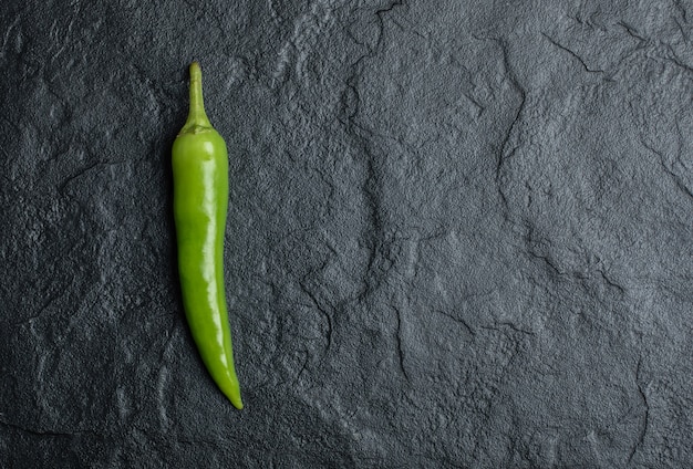 Un solo pimiento picante sobre fondo negro.