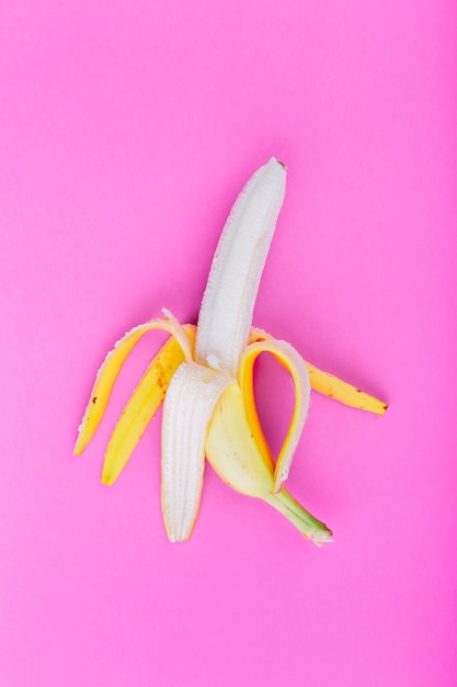 Solo plátano pelado sobre fondo rosa