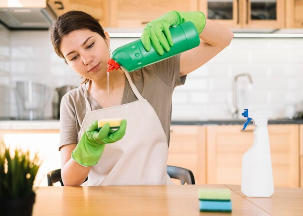 Solución de limpieza vertiendo mujer