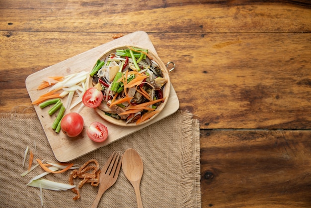 Som Tam Thai, ensalada de papaya tailandesa sobre fondo de madera