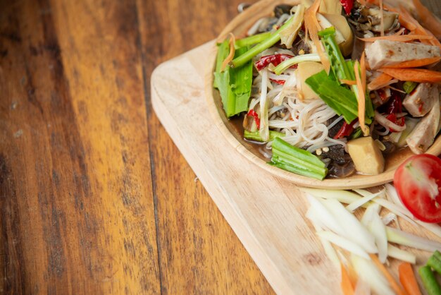 Som Tam Thai, ensalada de papaya tailandesa sobre fondo de madera