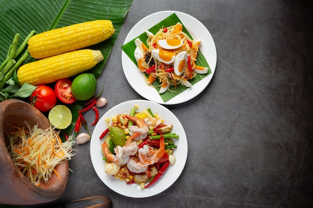 Foto gratuita som tum con maíz y camarones, servido con fideos de arroz y ensalada verde. decorado con ingredientes de comida tailandesa.