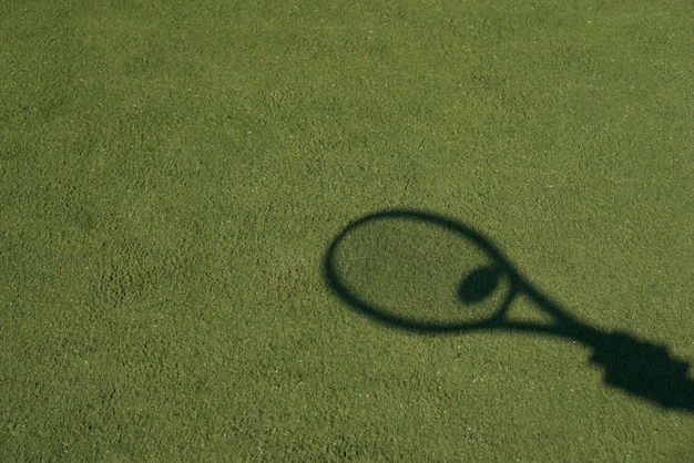 Foto gratuita sombra de una raqueta de tenis con una pelota.