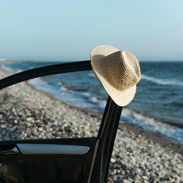 Sombrero colgando de la puerta del coche