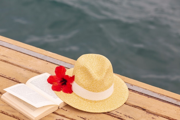 Foto gratuita sombrero y libro en el muelle