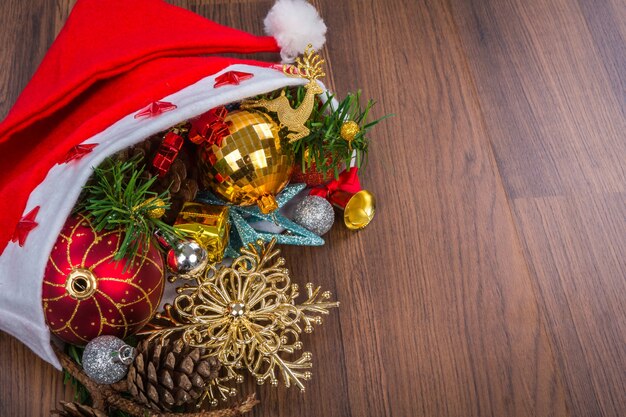 Sombrero de Santa con las decoraciones de Navidad en el fondo de madera