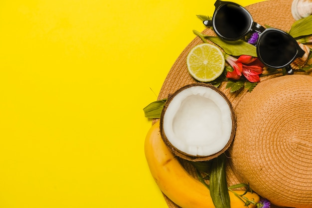 Sombrero veraniego con gafas de sol y elementos naturales 