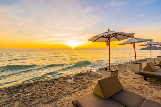 Sombrilla y silla con almohada alrededor del hermoso paisaje de playa y mar.