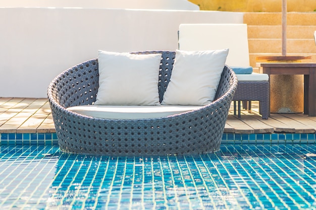 Sombrilla y silla alrededor de la piscina al aire libre en el hotel resort con vista al mar para viajes de vacaciones