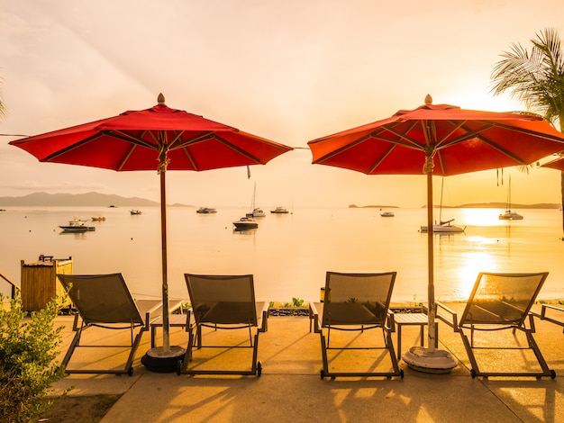 Foto gratuita sombrilla y silla alrededor de piscina al aire libre en hotel y resort