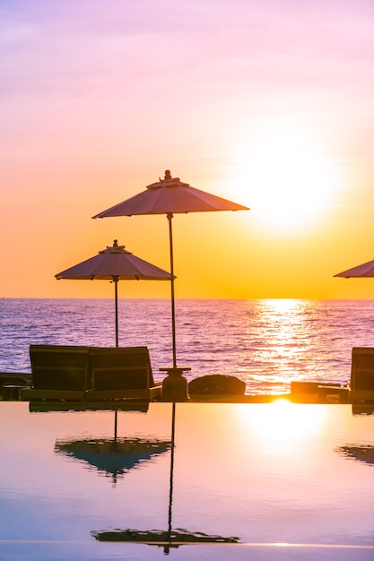Sombrilla y silla alrededor de la piscina en el hotel resort para viajes de placer y vacaciones