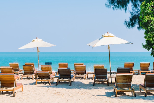 Foto gratuita sombrilla y silla en la playa.