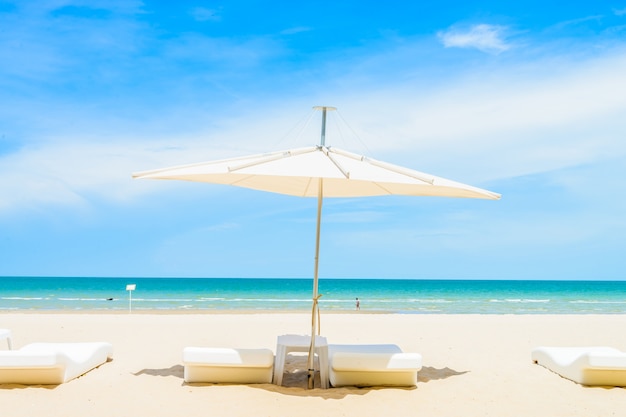 Foto gratuita sombrilla y silla en la playa.