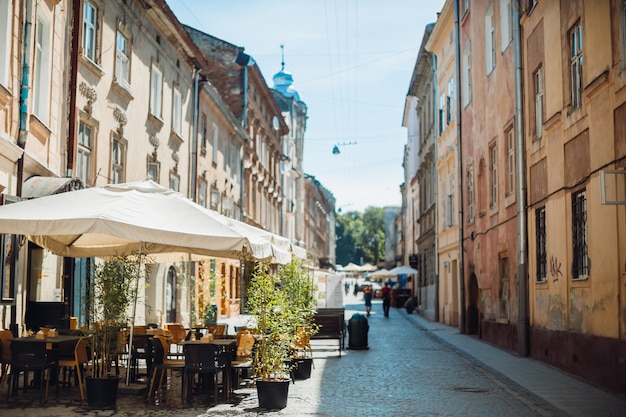 Sombrillas sobre las mesas en café en una calle vieja