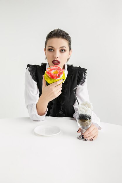 Somos lo que comemos. Mujer comiendo comida plástica, concepto ecológico