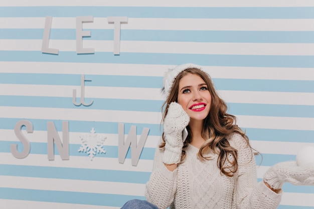 Foto gratuita soñadora joven de ojos azules en el estado de ánimo de año nuevo posando sentada en el suelo