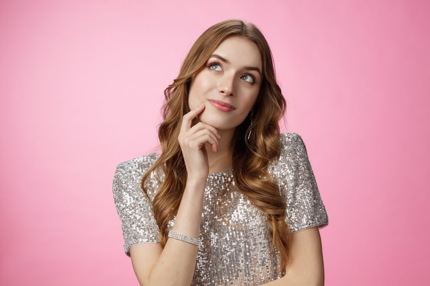 Foto gratuita soñadora linda mujer tonta de glamour decidiendo qué orden mirar hacia arriba reflexivo rostro conmovedor pensando tomar decisión elección imagen príncipe en caballo blanco, sonriendo despreocupado fondo rosa