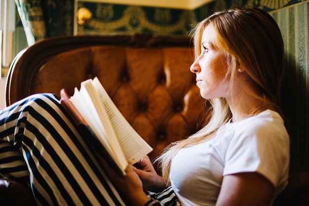 Foto gratuita soñando mujer con libro en casa