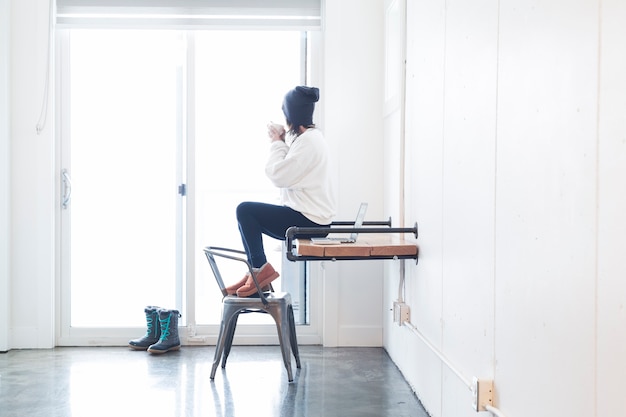 Soñando mujer tomando café en la oficina en casa