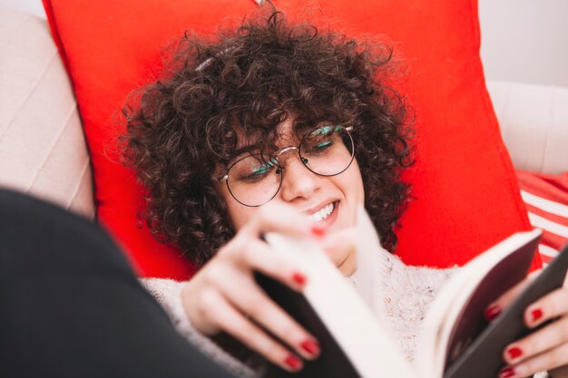 Sonriendo adolescente voltear las páginas del libro