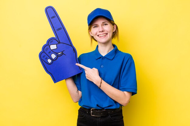 Sonriendo alegremente sintiéndose feliz y apuntando hacia un lado