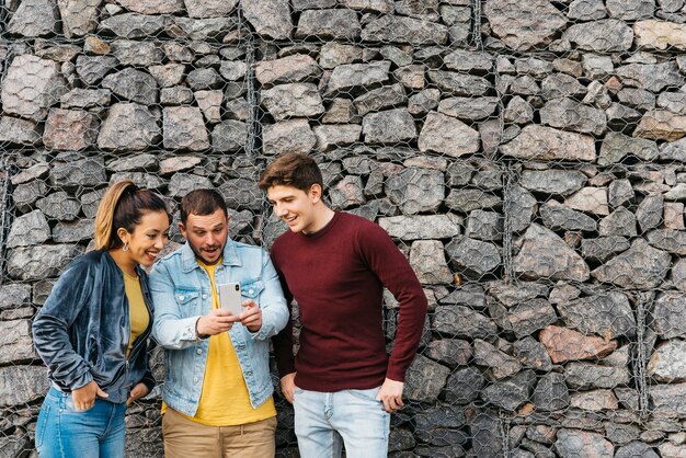 Sonriendo amigos multiétnicos tomando selfie en teléfono