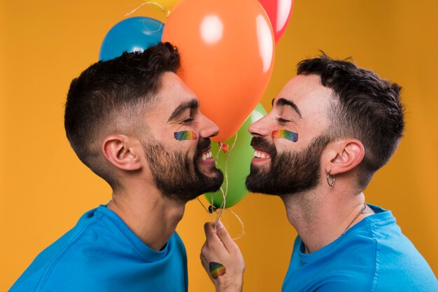 Sonriendo amorosos novios gay reunidos besándose