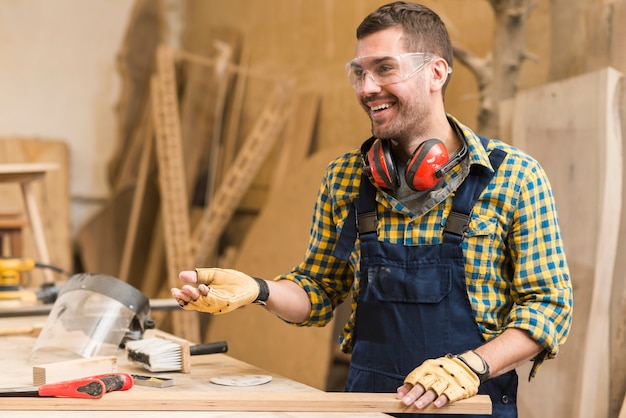 Sonriendo carpintero macho en el trabajo en el taller