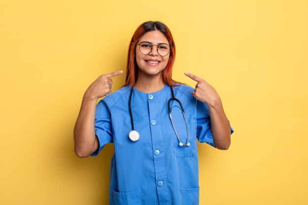 sonriendo con confianza señalando su propia sonrisa amplia