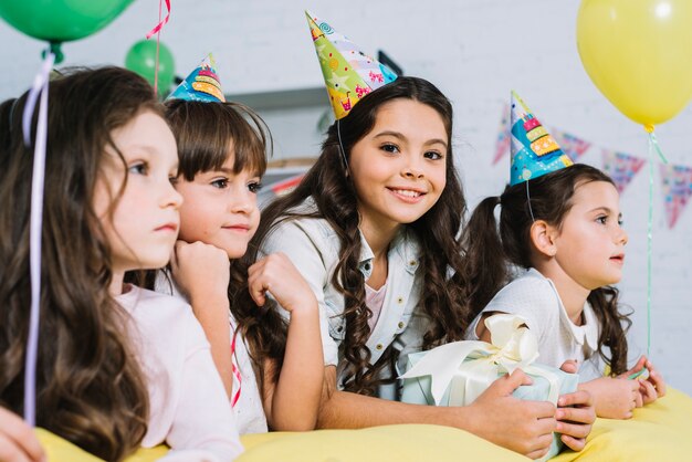Sonriendo cumpleaños niña con sus amigos disfrutando en la fiesta
