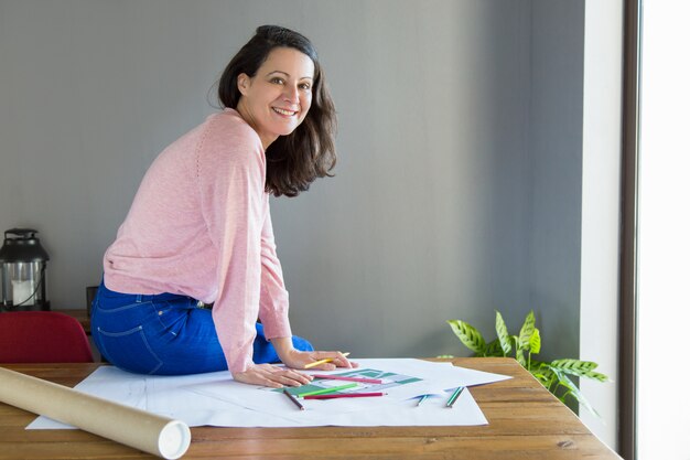 Sonriendo diseñador de interiores positivo trabajando en proyecto de renovación