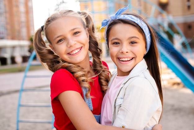 Sonriendo dos chicas abrazándose