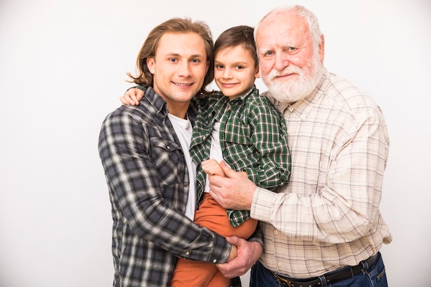 Foto gratuita sonriendo familia multigeneracional mirando a cámara