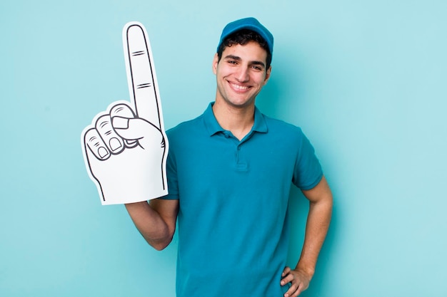 sonriendo felizmente con una mano en la cadera y confiado