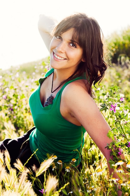 Sonriendo femenina sentada en el jardín